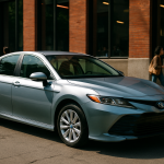carros híbridos — Um carro híbrido moderno estacionado em um ambiente urbano.